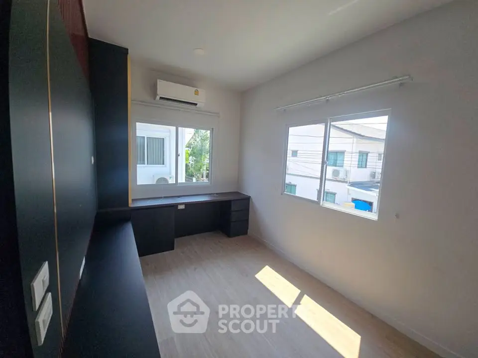 Spacious study room with large window and built-in desk, perfect for productivity and natural light.