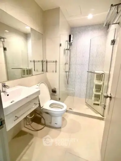 Modern bathroom with glass shower and sleek fixtures in a contemporary apartment.
