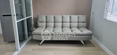 Modern living room with sleek gray sofa and glass sliding doors