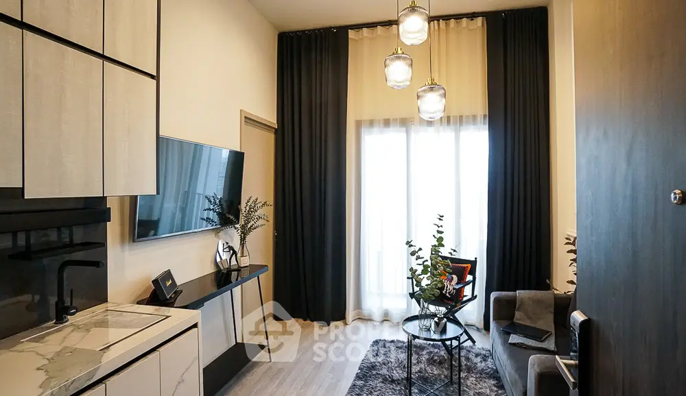Modern living room with stylish decor and large window, featuring sleek furniture and elegant lighting.