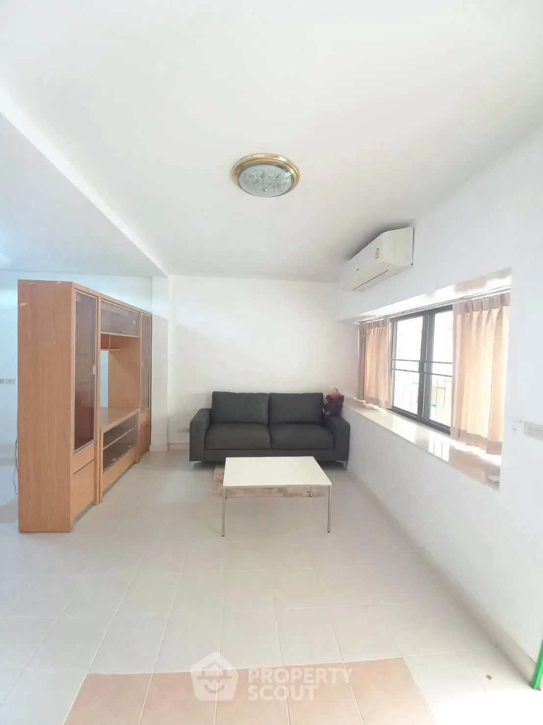 Bright living room with modern sofa and large window, perfect for relaxation.