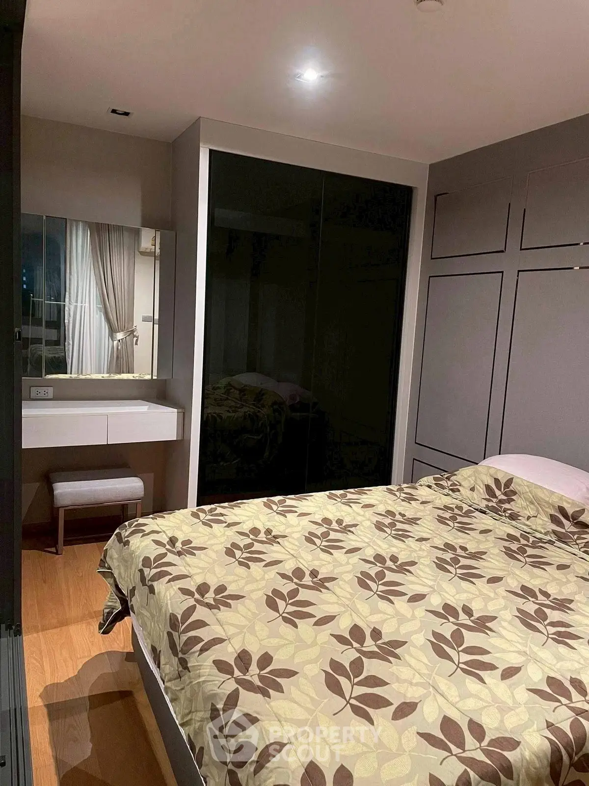 Cozy bedroom with modern decor and built-in wardrobe in stylish apartment.