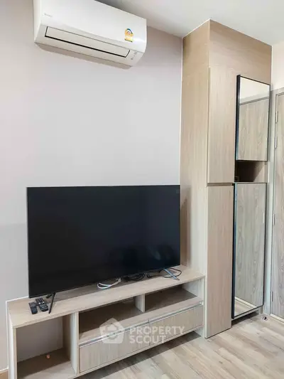 Modern living room with sleek TV setup and stylish wooden cabinetry.