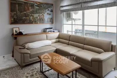 Spacious living room with modern leather sofa and large window view.
