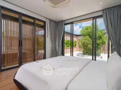 Luxurious bedroom with large windows and garden view in modern home