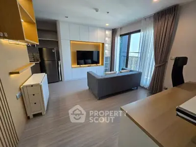 Modern living room with sleek design, featuring a cozy sofa, large TV, and balcony access.