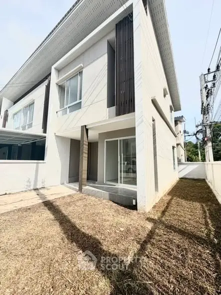 Modern two-story house with sleek design and spacious outdoor area, perfect for family living.