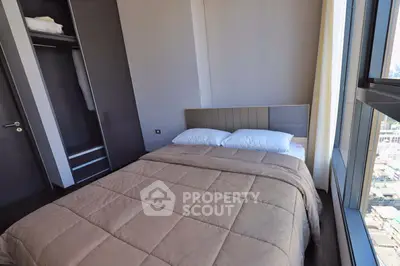 Modern bedroom with large window offering city views and built-in closet