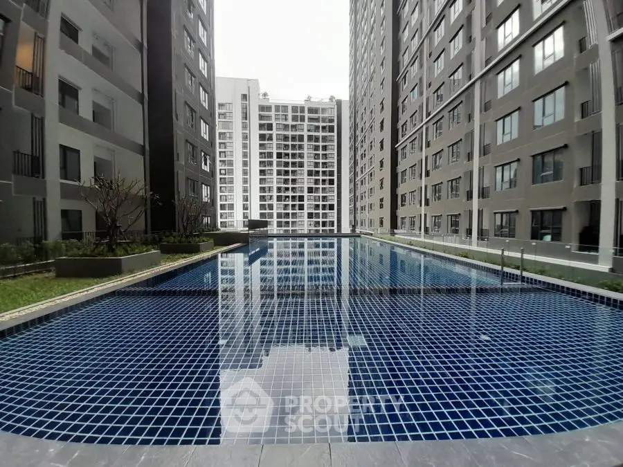 Luxurious apartment complex with a stunning outdoor pool and modern architecture.