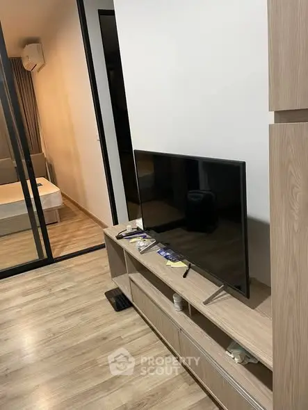 Modern apartment with sleek TV unit and cozy bedroom view, perfect for urban living.