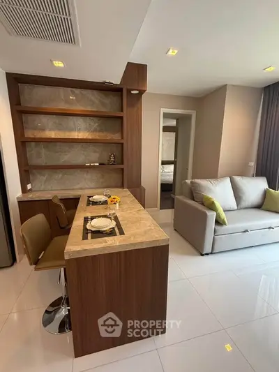 Modern living room with stylish open kitchen and cozy seating area in a contemporary apartment.