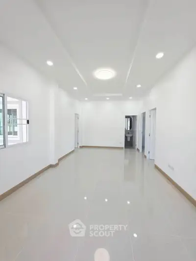 Spacious modern living room with glossy tiled floors and recessed lighting