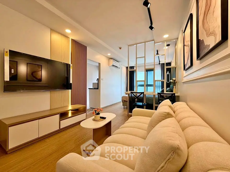 Modern living room with stylish decor and open layout, featuring a cozy sofa and wall-mounted TV.