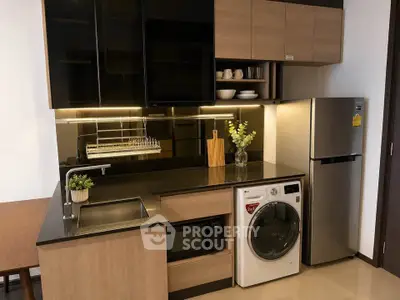 Modern kitchen with sleek cabinetry, built-in appliances, and stylish lighting