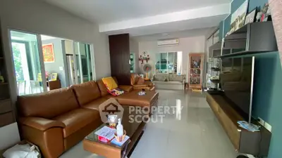 Spacious living room with modern brown leather sofas and sleek entertainment unit