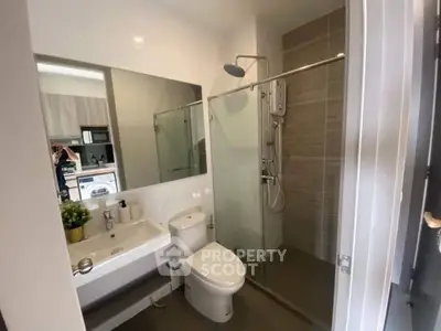 Modern bathroom with glass shower and sleek fixtures in a contemporary home.
