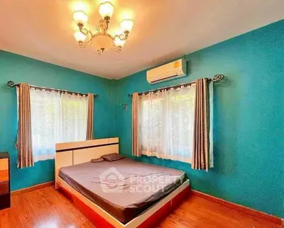 Charming bedroom with vibrant teal walls and elegant chandelier lighting.