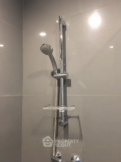 Modern bathroom shower with sleek chrome fixtures and elegant tile design.