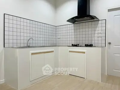 Modern kitchen with sleek design, featuring gas stove and stylish backsplash.