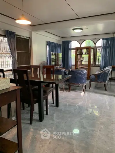 Spacious living room with elegant dining area and large windows for natural light.
