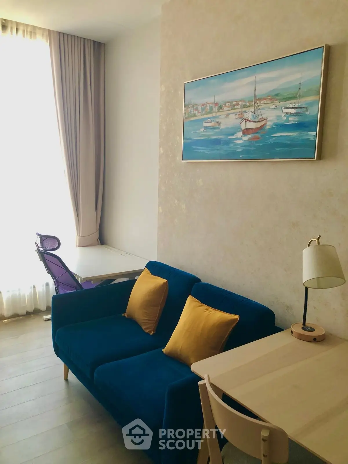 Charming living room with cozy blue sofa, stylish decor, and natural light, perfect for relaxation and work.