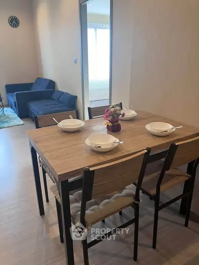 Modern dining area with wooden table and chairs in cozy apartment setting.