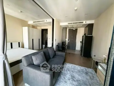 Modern studio apartment with sleek furniture and open layout, featuring a cozy living area and stylish decor.