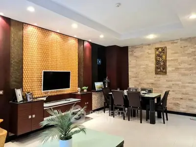Elegant living room with modern decor and dining area, featuring stylish lighting and textured walls.