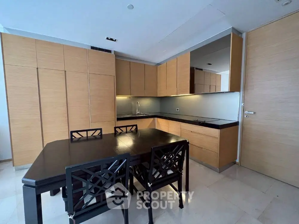 Modern kitchen with sleek cabinetry and dining table in a stylish apartment.