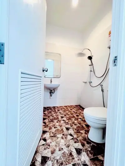 Compact bathroom with modern fixtures and unique patterned flooring.