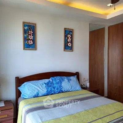 Cozy bedroom with stylish decor and ample natural light, featuring a comfortable bed and elegant wall art.