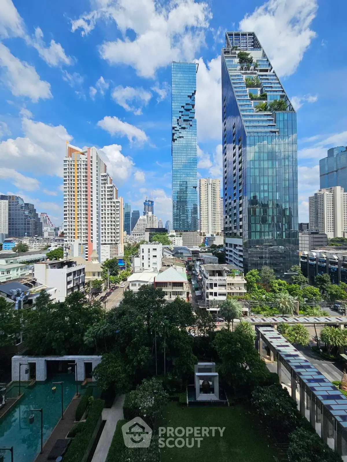 Stunning cityscape view with modern skyscrapers and lush greenery, perfect for urban living.