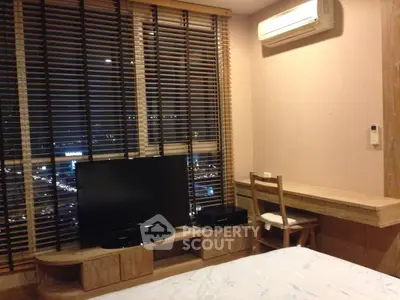 Modern bedroom with city view, featuring large windows, wooden blinds, and a wall-mounted air conditioner.