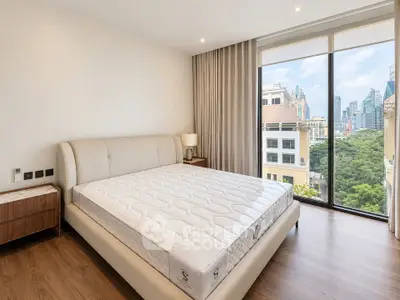 Spacious bedroom with city view and modern furnishings in luxury apartment