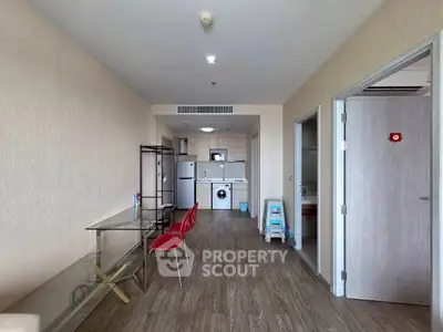 Modern apartment interior with open kitchen and dining area, featuring sleek appliances and stylish flooring.