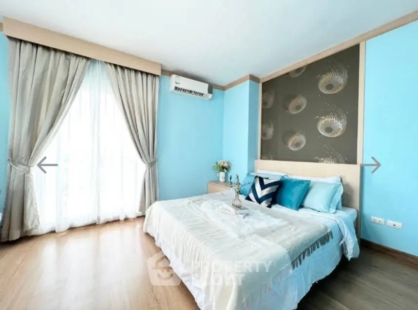 Bright and airy bedroom with elegant decor and large window for natural light.