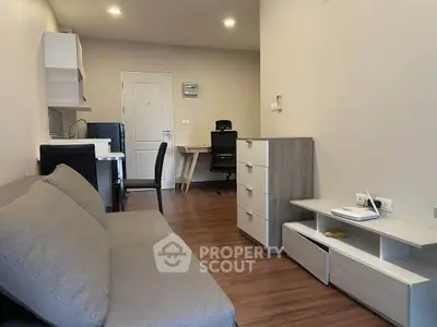 Modern living room with sleek furniture and wooden flooring in a cozy apartment.