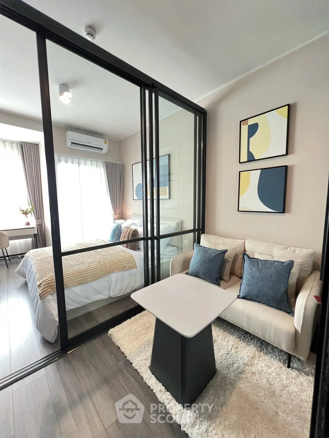 Modern studio apartment with glass partition, cozy living area, and stylish decor