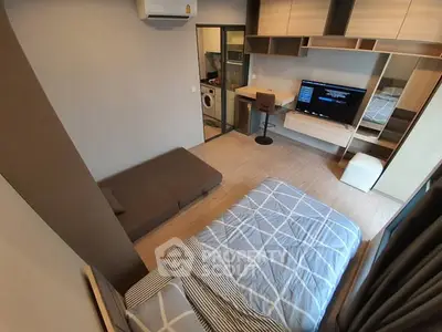 Modern bedroom with stylish decor and built-in storage, featuring a cozy bed and a compact workspace.