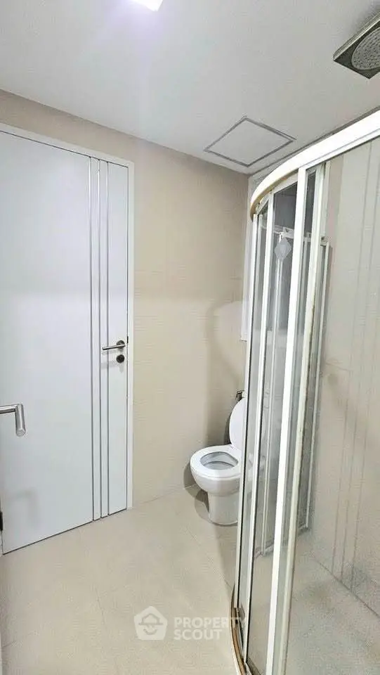 Modern bathroom with shower and toilet in sleek minimalist design.