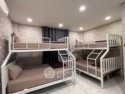 Spacious bedroom with modern bunk beds and stylish brick walls, perfect for family living.
