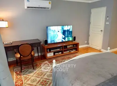 Cozy bedroom with elegant decor, featuring a TV, desk, and air conditioning.