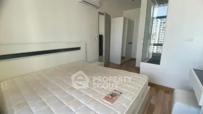 Modern bedroom with large window and air conditioning in a high-rise apartment.