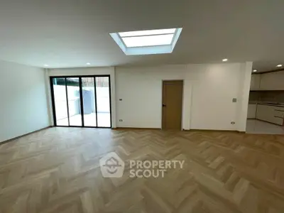 Spacious modern living room with skylight and herringbone flooring