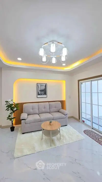 Modern living room with elegant lighting and cozy sofa, featuring a stylish coffee table and chic decor.