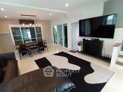 Modern living room with large TV and stylish dining area
