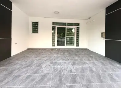 Spacious modern entrance with sleek tiled flooring and large glass doors