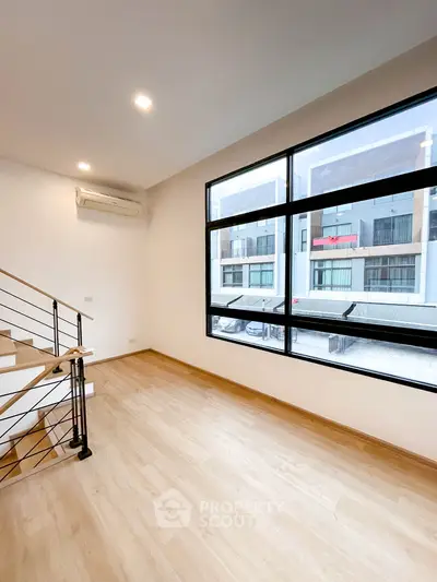 Spacious modern living room with large windows and wooden flooring