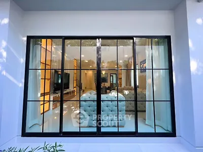 Luxurious living room with large glass windows and elegant interior design.