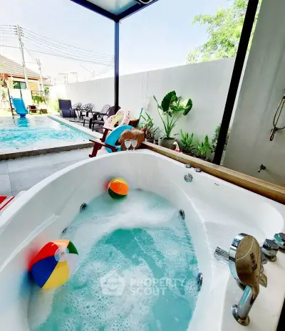 Luxurious outdoor bathtub with pool view, perfect for relaxation and leisure in a serene setting.